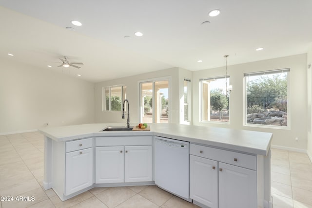 kitchen with a wealth of natural light, sink, white dishwasher, a center island with sink, and white cabinets