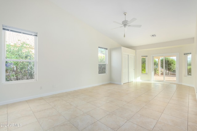 tiled spare room featuring ceiling fan, a healthy amount of sunlight, and high vaulted ceiling