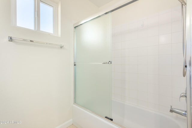 bathroom with shower / bath combination with glass door