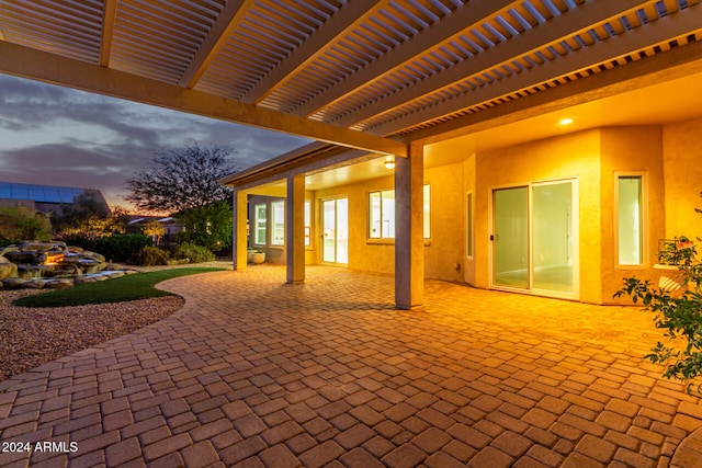 patio terrace at dusk featuring a pergola