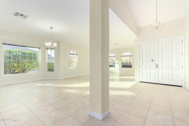 tiled entrance foyer with high vaulted ceiling and a chandelier