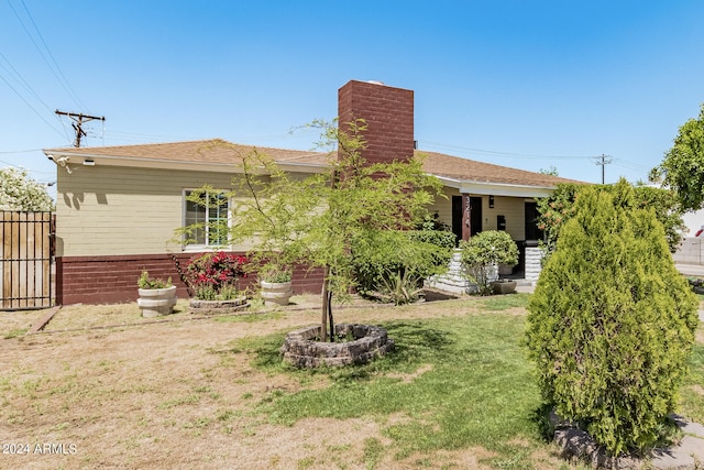 rear view of property featuring a lawn