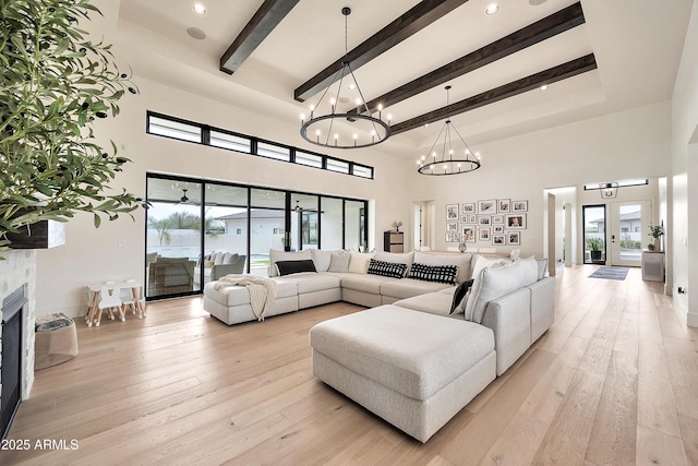 living room featuring beam ceiling, light hardwood / wood-style flooring, and a high ceiling