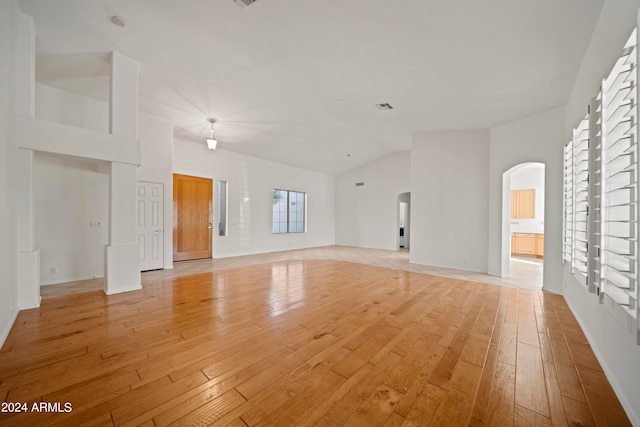 unfurnished living room featuring light wood-type flooring and high vaulted ceiling