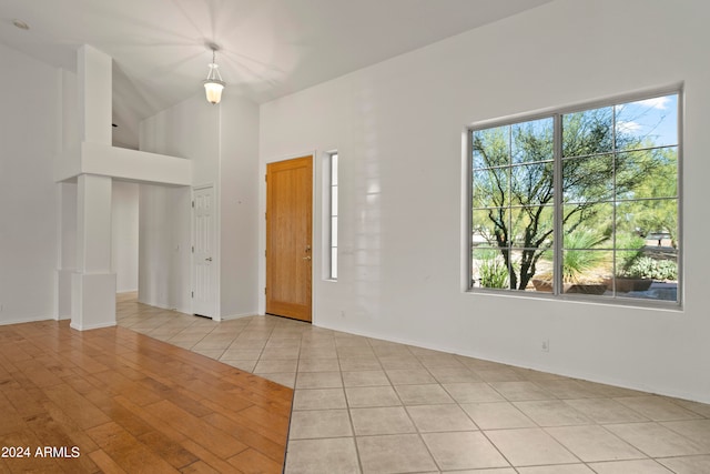 tiled spare room with lofted ceiling