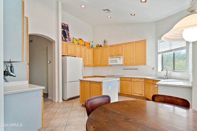 kitchen featuring vaulted ceiling, white appliances, light brown cabinets, a center island, and sink