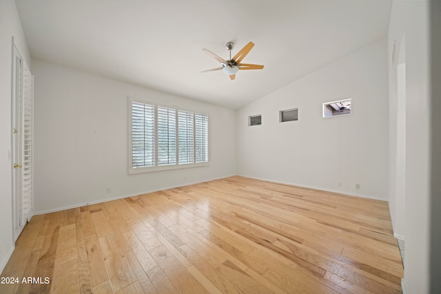 empty room featuring ceiling fan, light wood-type flooring, and lofted ceiling