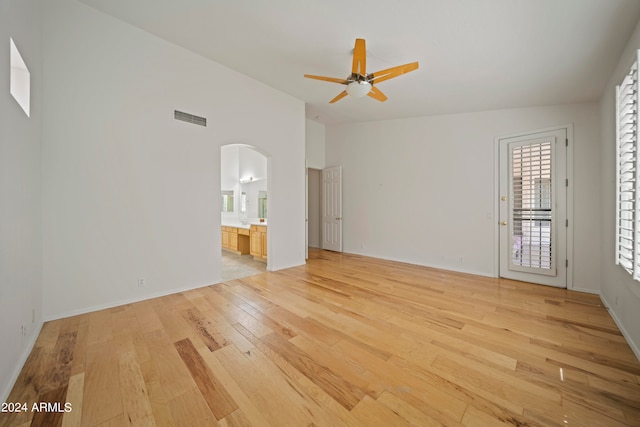 spare room featuring ceiling fan, light wood-type flooring, and lofted ceiling