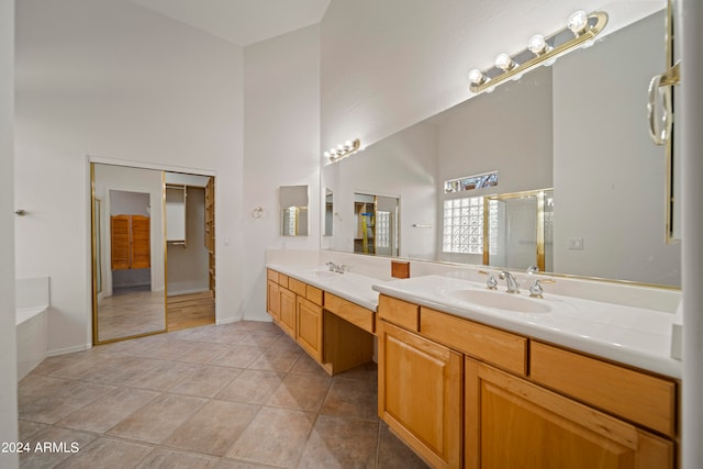 bathroom featuring a high ceiling, tile patterned floors, independent shower and bath, and vanity