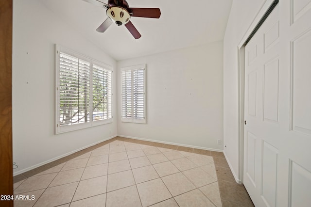 spare room with vaulted ceiling, ceiling fan, and light tile patterned floors