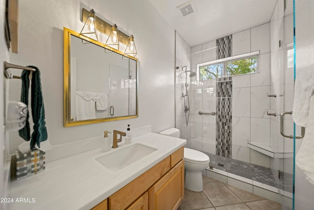 bathroom with vanity, toilet, tile patterned floors, and a shower with shower door