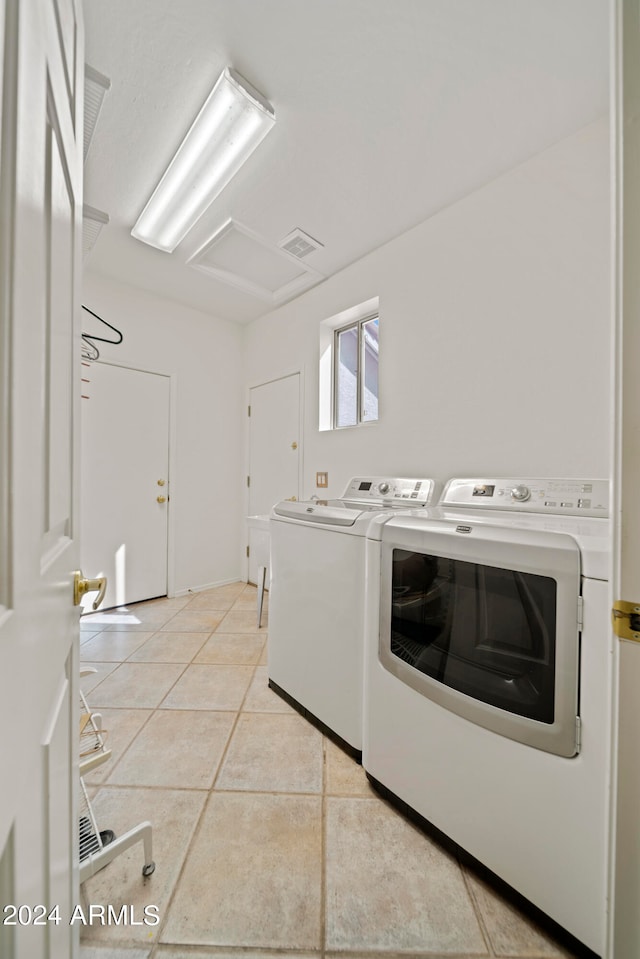 laundry area featuring light tile patterned floors and washing machine and dryer