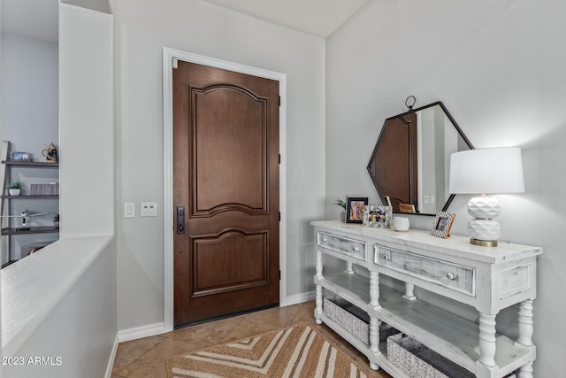 foyer with baseboards and light tile patterned flooring