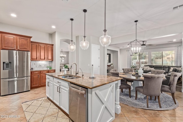 kitchen with open floor plan, appliances with stainless steel finishes, an inviting chandelier, and a sink