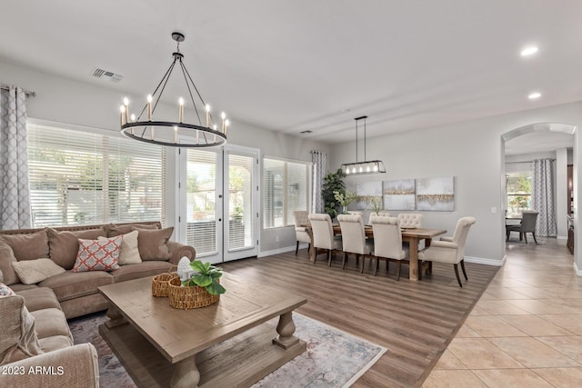 living room with visible vents, a notable chandelier, recessed lighting, and arched walkways