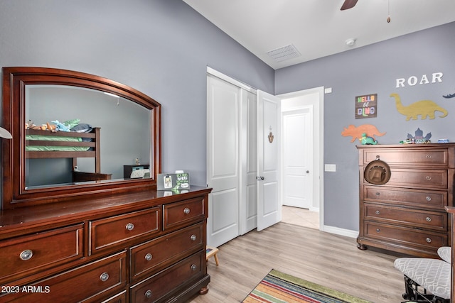 bedroom with a ceiling fan, visible vents, baseboards, light wood-style floors, and a closet