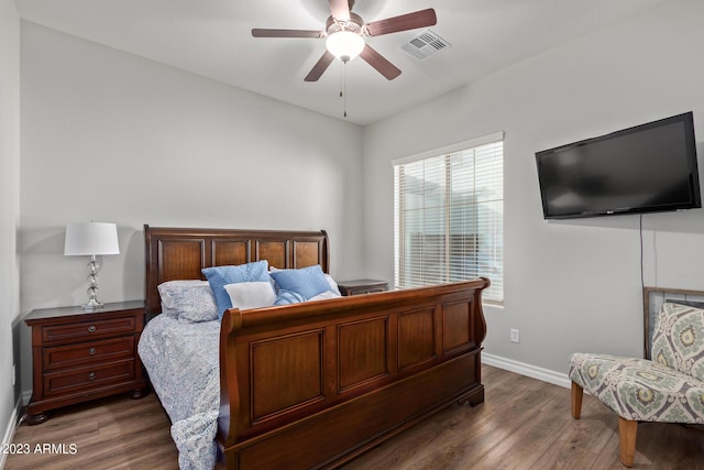 bedroom featuring a ceiling fan, wood finished floors, visible vents, and baseboards