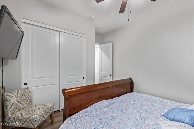 bedroom featuring a closet, visible vents, ceiling fan, and wood finished floors