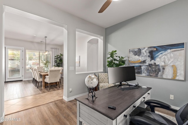 office featuring baseboards, light wood-type flooring, and ceiling fan