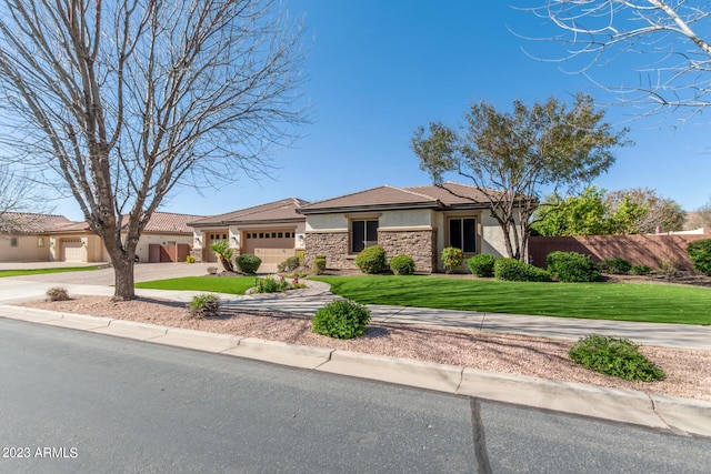 view of front facade featuring a front yard, fence, stucco siding, a garage, and stone siding