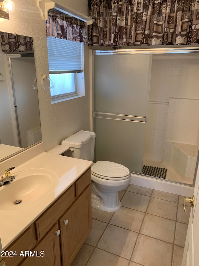 bathroom featuring toilet, walk in shower, tile patterned floors, and vanity