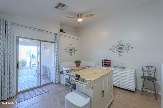 kitchen featuring ceiling fan, butcher block counters, white cabinetry, and light tile patterned floors