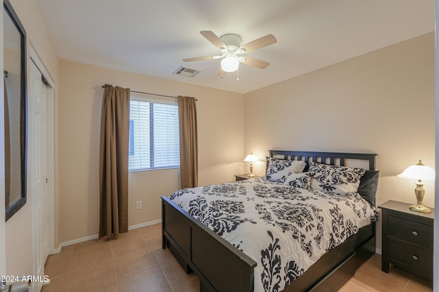 bedroom featuring light tile patterned floors, a closet, and ceiling fan