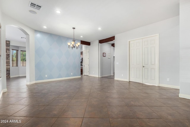 unfurnished room with a chandelier