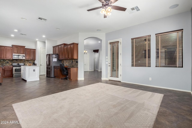 kitchen with tasteful backsplash, stainless steel appliances, dark tile patterned floors, and ceiling fan