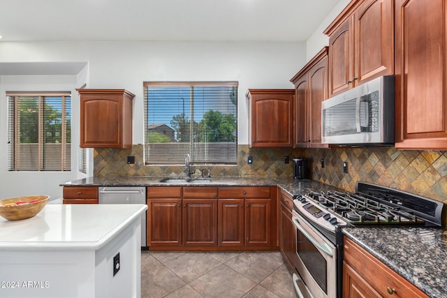 kitchen featuring decorative backsplash, light tile patterned floors, stainless steel appliances, and sink