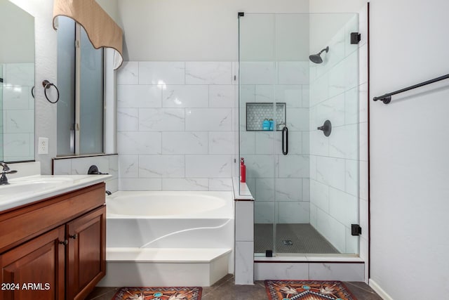 bathroom featuring tile patterned flooring, vanity, and shower with separate bathtub