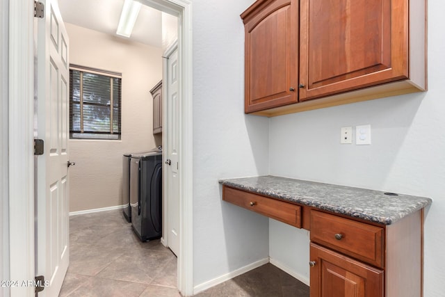 laundry room featuring washer and clothes dryer, light tile patterned floors, and cabinets