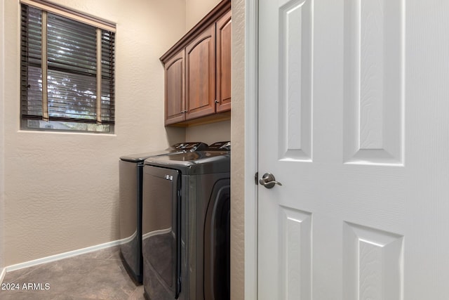 washroom featuring cabinets, light tile patterned floors, and washing machine and clothes dryer