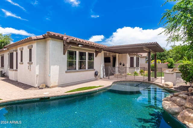 rear view of house with a pergola, a patio area, and a fenced in pool