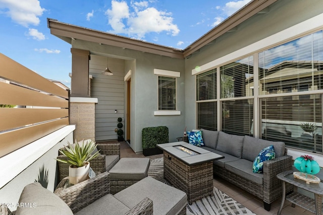 view of patio with an outdoor living space with a fire pit