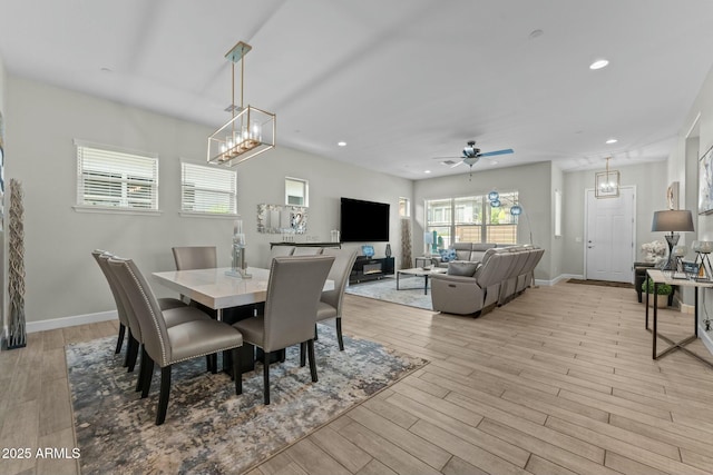 dining area with ceiling fan with notable chandelier, light wood-type flooring, baseboards, and recessed lighting