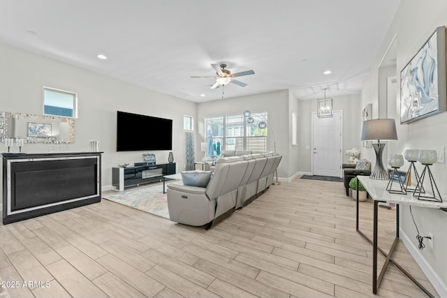 living area with light wood-style floors, recessed lighting, baseboards, and a ceiling fan