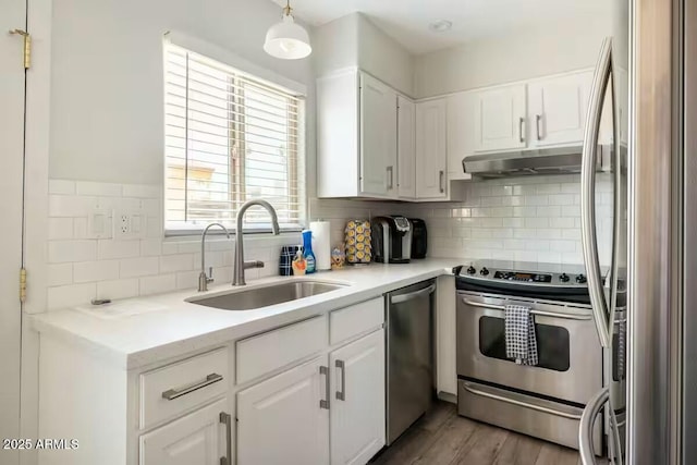 kitchen with stainless steel appliances, decorative light fixtures, sink, and white cabinets