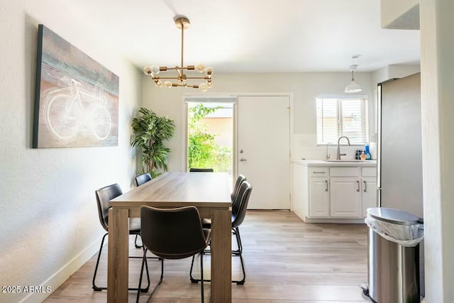 dining area featuring a chandelier, light hardwood / wood-style floors, and sink