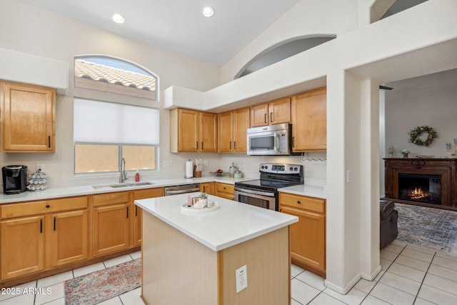4918 W Wahalla Ln, Glendale, AZ 85308 - kitchen with appliances with stainless steel finishes, light tile patterned floors, light countertops, a glass covered fireplace, and a center island