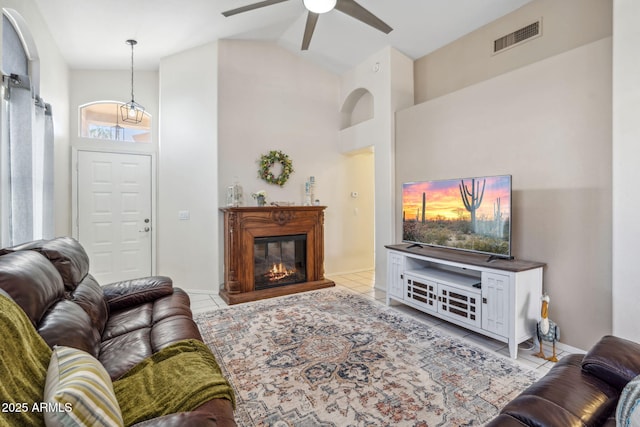 4918 W Wahalla Ln, Glendale, AZ 85308 - tiled living room with ceiling fan, high vaulted ceiling, and a glass covered fireplace