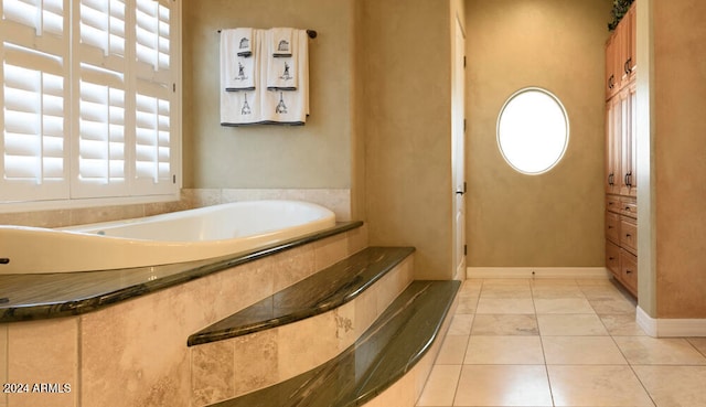 bathroom with tile patterned floors and a bath