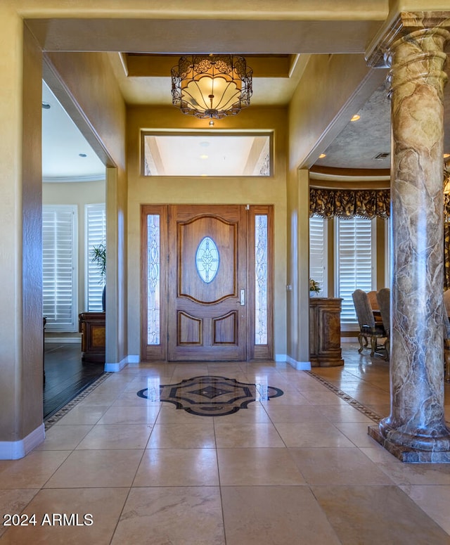 foyer featuring tile patterned floors and ornate columns