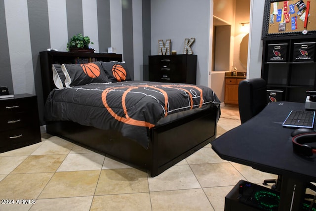 bedroom with ensuite bath and light tile patterned floors