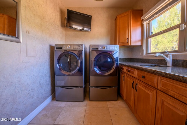 clothes washing area with cabinets, independent washer and dryer, sink, and light tile patterned floors