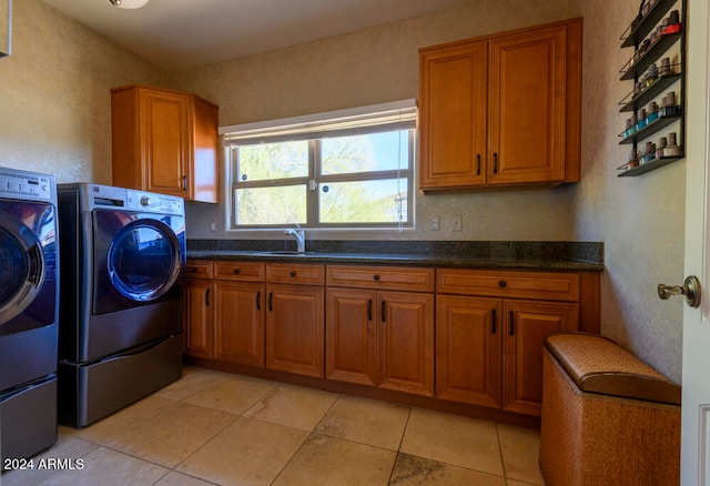 clothes washing area featuring washer and clothes dryer, light tile patterned flooring, cabinets, and sink