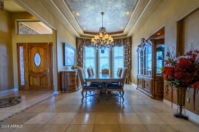 tiled dining room with a raised ceiling and a notable chandelier