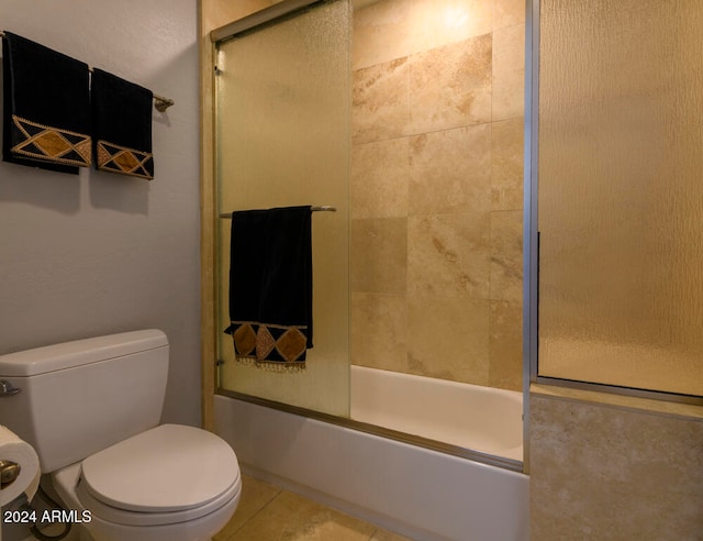 bathroom with shower / bath combination with glass door, tile patterned flooring, and toilet