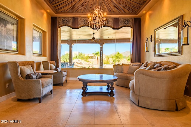 living room featuring a raised ceiling, light tile patterned floors, and a chandelier