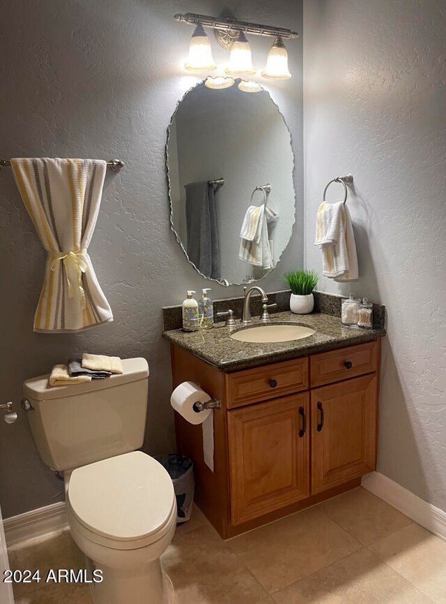 bathroom with tile patterned flooring, vanity, and toilet